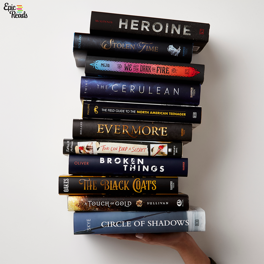 A hand holding a stack of Epic Reads books
